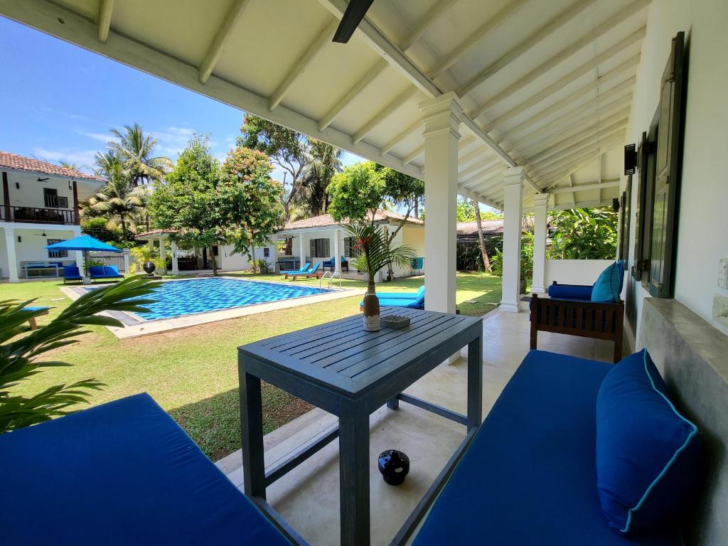 a patio with a table and a swimming pool at Thalpe Bungalows in Unawatuna