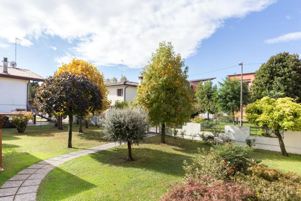 ogród z drzewami i chodnikiem w obiekcie Home Near Venice w mieście Favaro Veneto