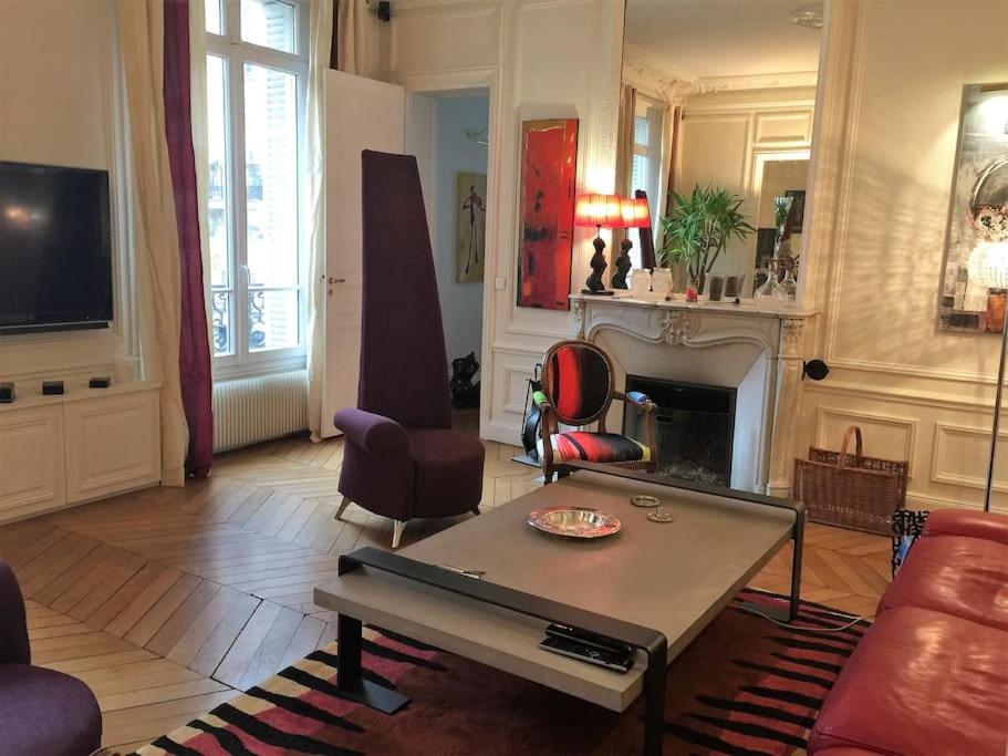 un salon avec une table et une cheminée dans l'établissement 5 minutes Village Olympique Tour Eiffel, à Paris