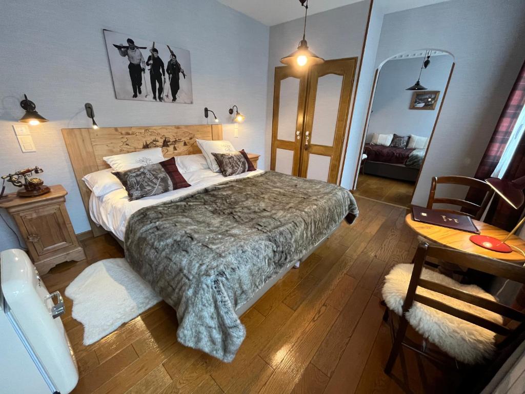 1 dormitorio con 1 cama grande, mesa y escritorio en Hôtel du Lion d'Or en Cauterets