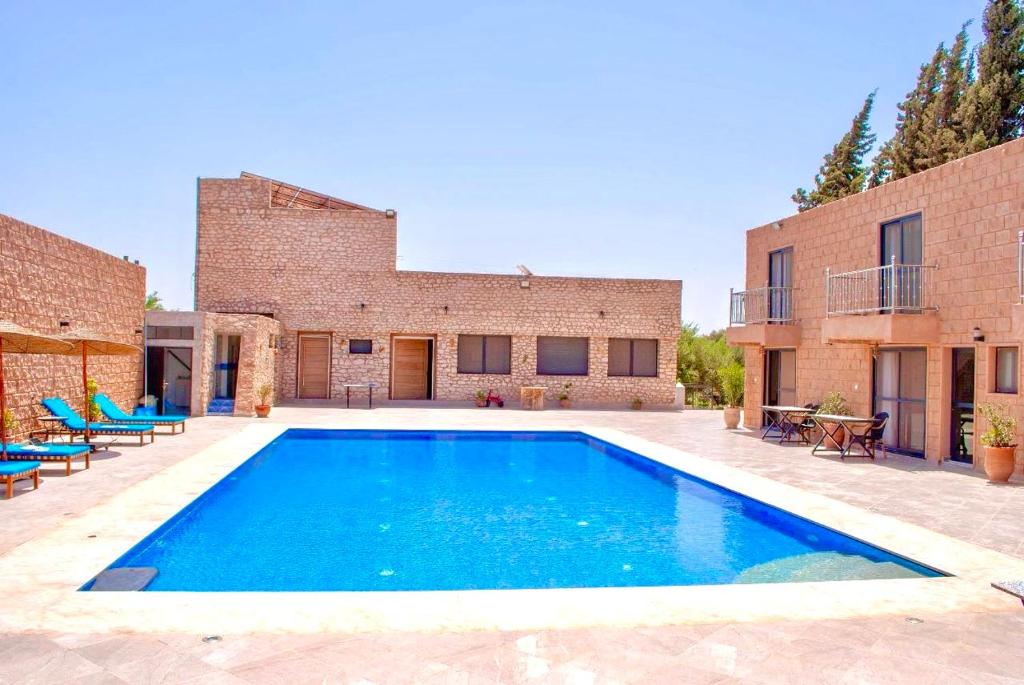 una piscina frente a un edificio de ladrillo en bungalows vert 2 en Essaouira