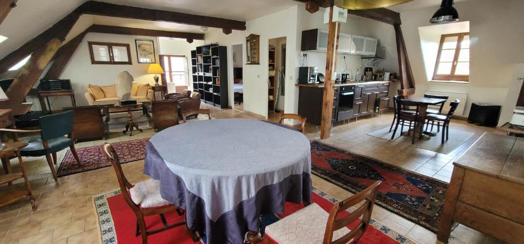 Mauves-sur-HuisneにあるF3 tout confort spacieuxの広いリビングルーム(テーブル、椅子付)