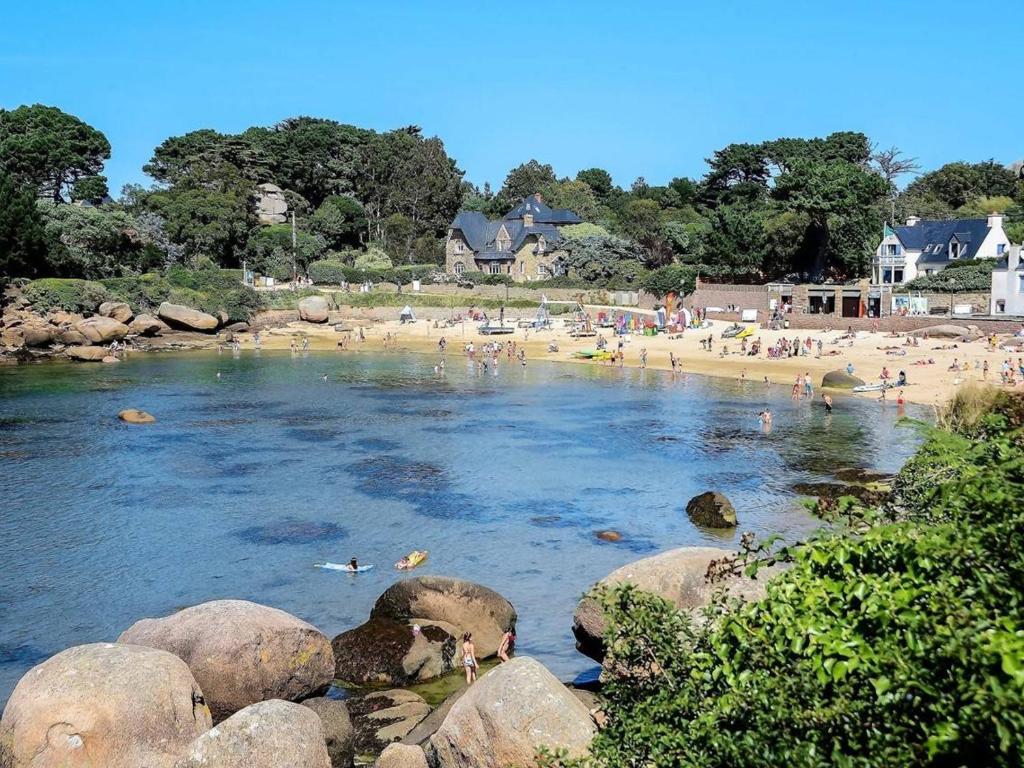 une plage avec une bande de gens qui nagent dans l'eau dans l'établissement Appartement mansardé avec terrasse à 100m de la Plage St-Guirec, Ploumanac'h - FR-1-368-161, à Perros-Guirec