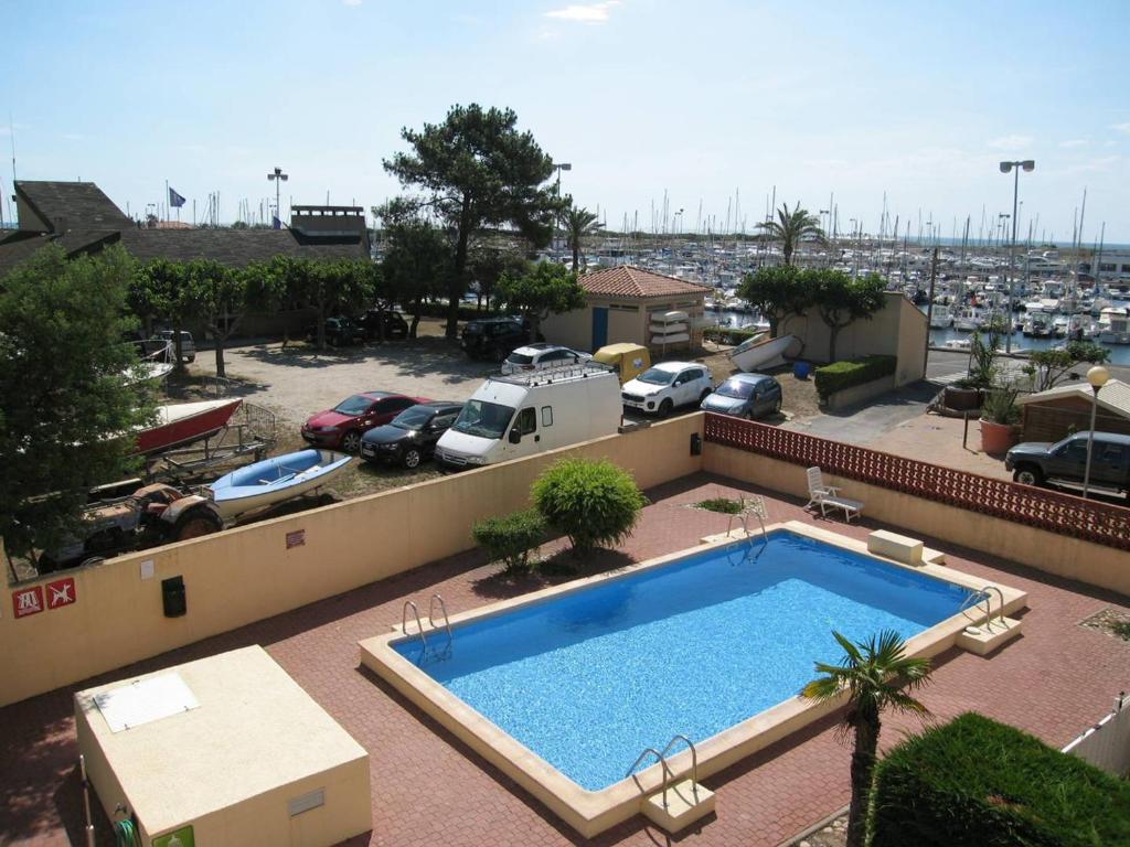 - une piscine au-dessus d'un immeuble avec un parking dans l'établissement T2 Port St Cyprien Piscine, Clim, Parking, Animaux Ok - FR-1-106-39, à Saint-Cyprien