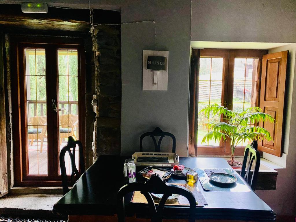 una sala da pranzo con tavolo, sedie e finestra di Casa Mayor a Gordexola