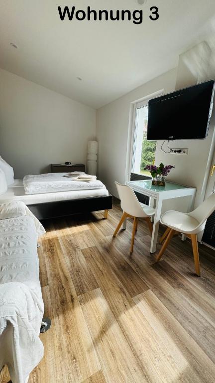 a bedroom with a bed and a desk and a tv at Ferienwohnung Felix in Templin