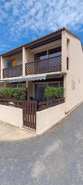 un bâtiment avec un balcon avec des plantes dessus dans l'établissement Maison près de la plage, à Port-la-Nouvelle