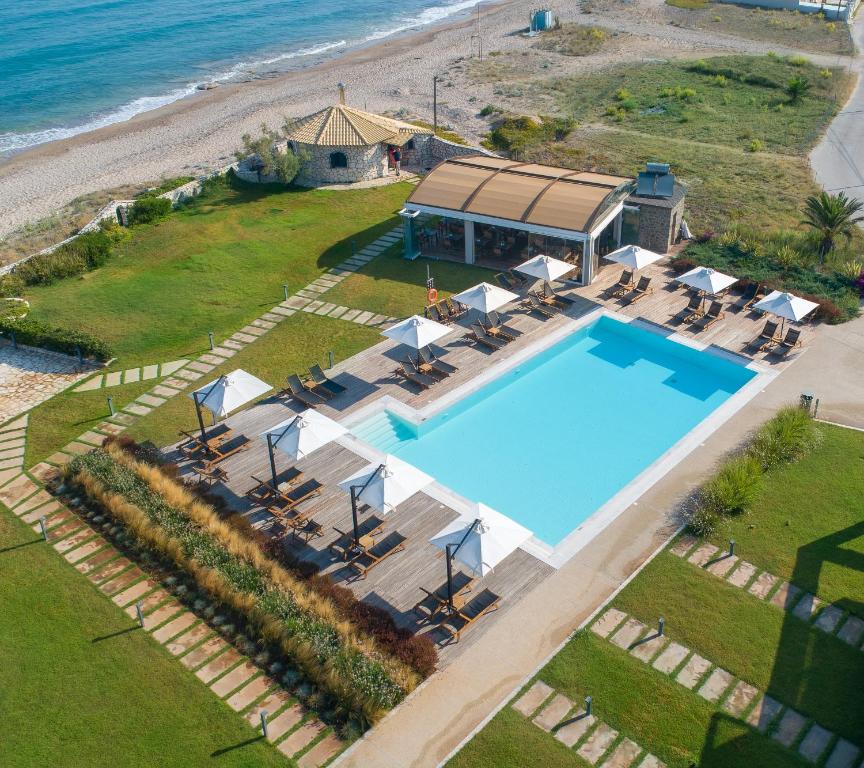 una vista panoramica su una piscina accanto alla spiaggia di Kyma Suites - adult only accommodation ad Almiros Beach