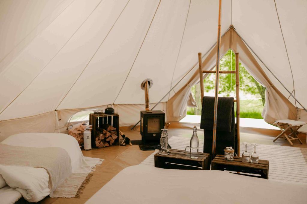 um quarto com uma tenda com uma cama e uma televisão em Falkeröd - Lyxig glamping i naturreservat ink frukost em Grebbestad