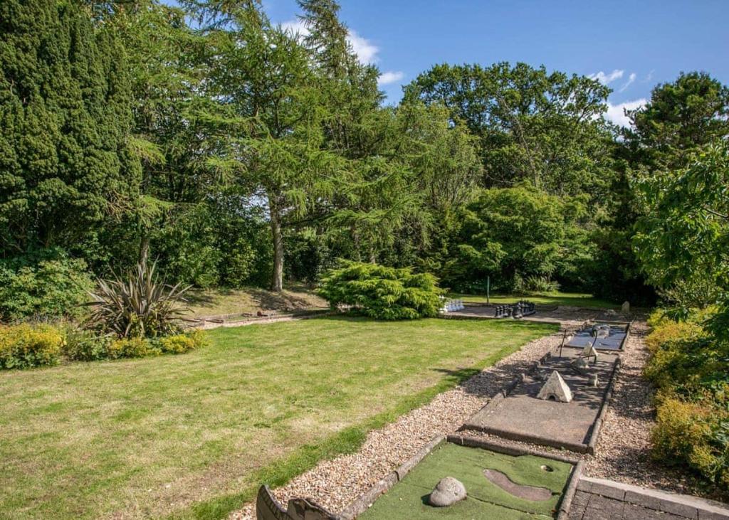 um jardim com relva, rochas e árvores em Blaithwaite Country House Estate em Wigton