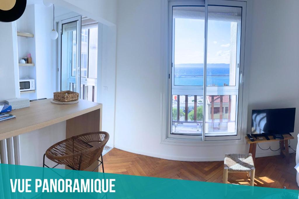 a living room with two chairs and a large window at Le Mucem du Vieux Port in Marseille