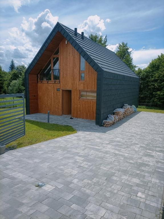 a large building with a black roof and a patio at Czarna Chata in Jaworzynka