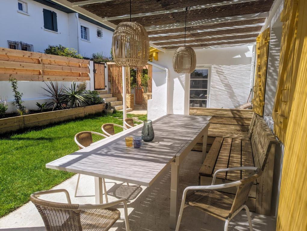 Una mesa y sillas de madera en un patio. en Maison de pêcheur à 10 minutes à pied de Saint Jean de Luz, en Ciboure