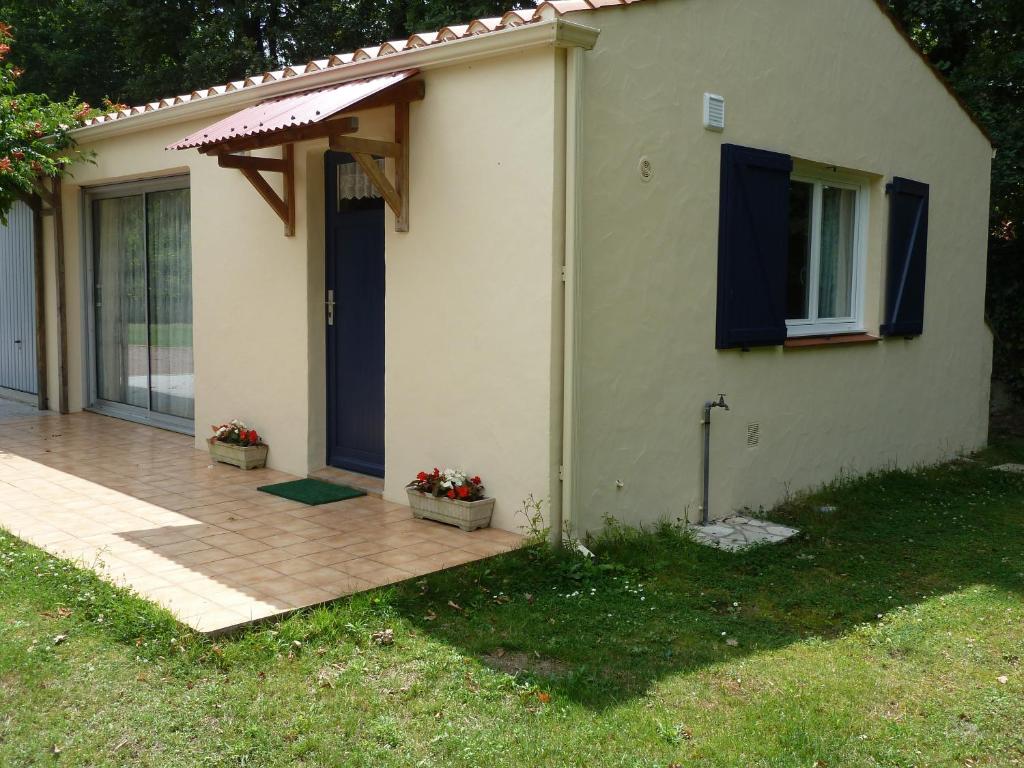 a small house with a porch and a blue door at Gîte 2 personnes, proche mer in Challans