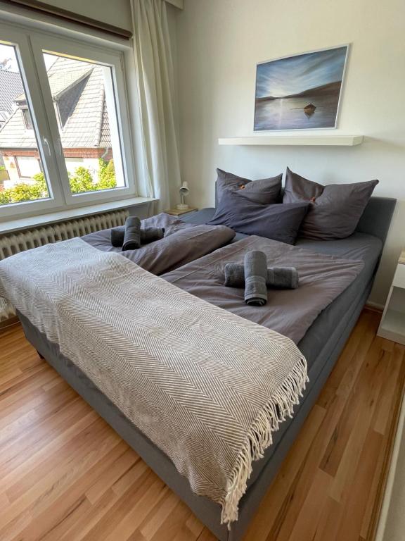 a large bed in a room with two large windows at LUV & LEE Waterkant Ferienwohnung SPO in Sankt Peter-Ording