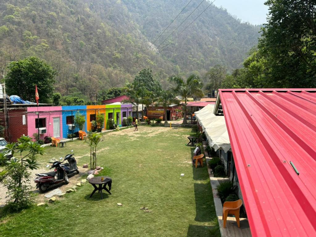 a group of buildings in a town with a mountain at The FnF Resort & Camping - Rishikehs in Rishīkesh