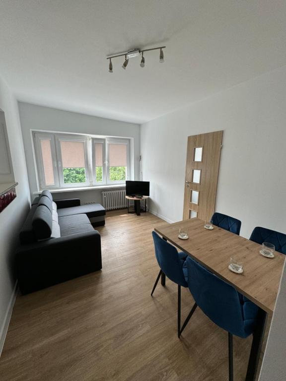a living room with a table and a couch at Mallborro - Z widokiem na zamek in Malbork