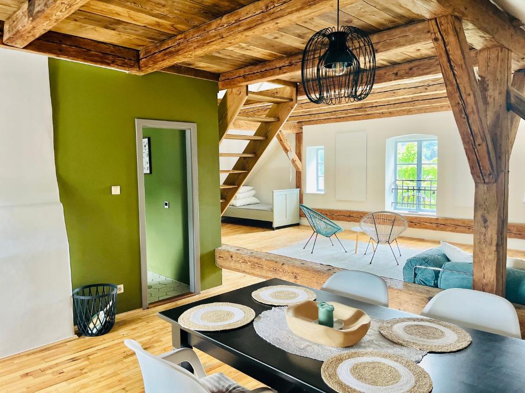 a living room with a table and a green wall at Na Nebi 187 in Bečov nad Teplou