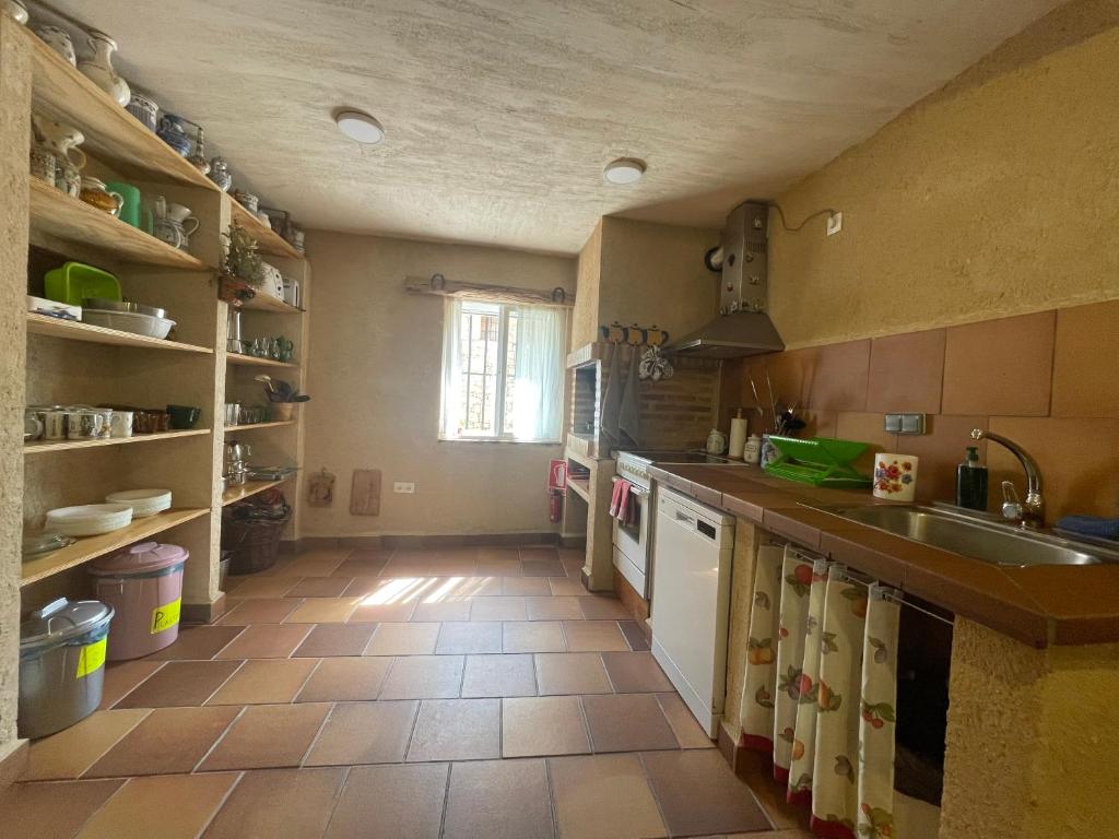 eine Küche mit Fliesenboden und einem Waschbecken in der Unterkunft La Casa de mis Padres in Arahuetes