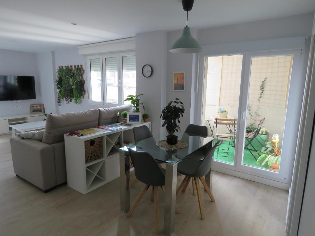 sala de estar con sofá, mesa y sillas en Apartamento Cué, en Gijón