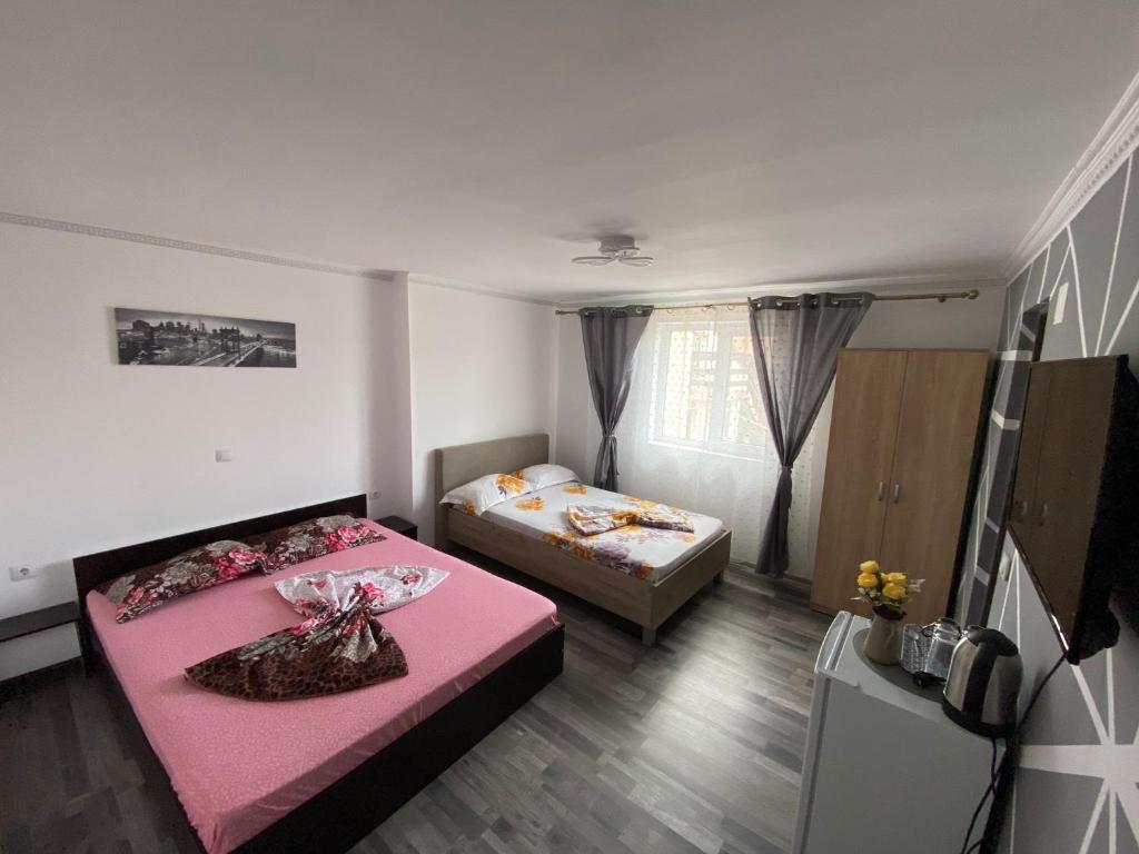 um pequeno quarto com 2 camas e uma televisão em Casa Tomița em 2 Mai