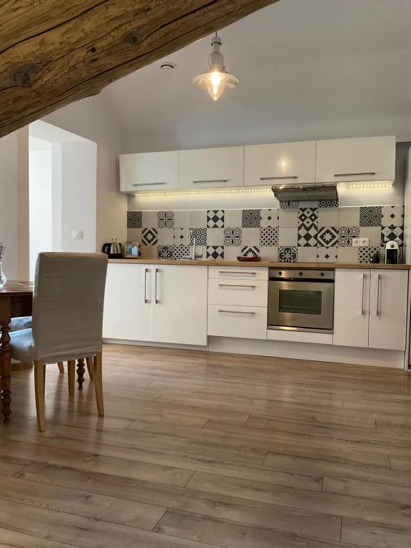 a kitchen with white cabinets and a wooden table at Villa Colonna Appartements in Manosque