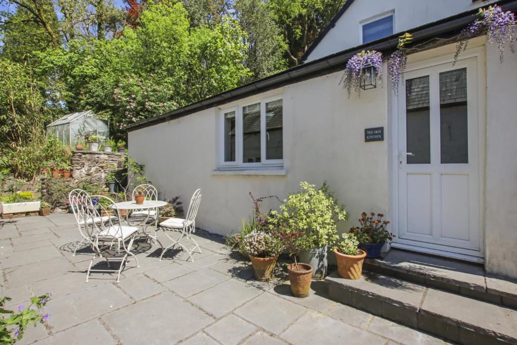 un patio con tavolo e sedie di fronte a una casa di The Old Kitchen Exford a Wheddon Cross