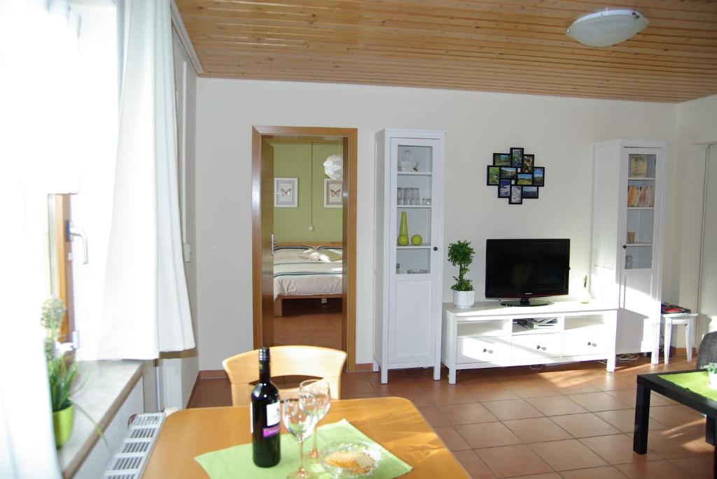a living room with a table and a television at Haus Föhrenbach in Schönenberg