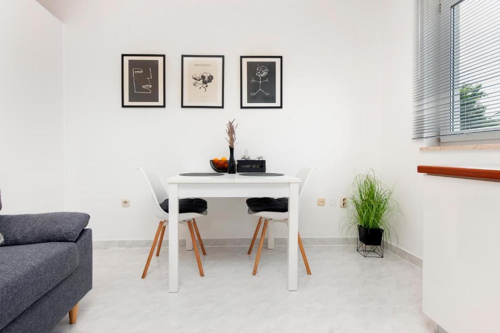 a white table and chairs in a living room at Apartman NEVERA in Rovinj
