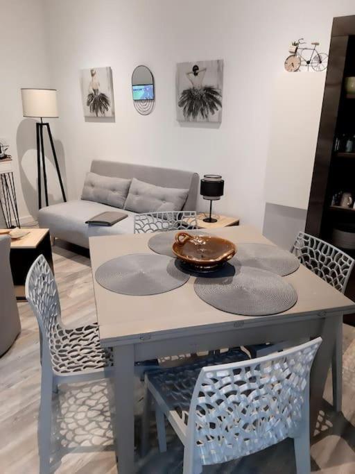 une table à manger et des chaises dans un salon dans l'établissement Appartement Au Murmure des Eaux à Fontaine-de-Vaucluse, à Fontaine-de-Vaucluse