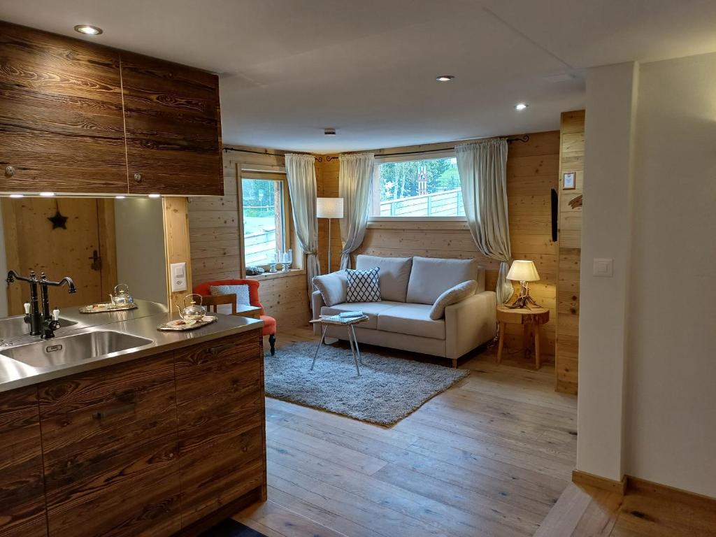 una cucina e un soggiorno con divano e tavolo di Hotel Chesa Staila a La Punt-Chamues-ch