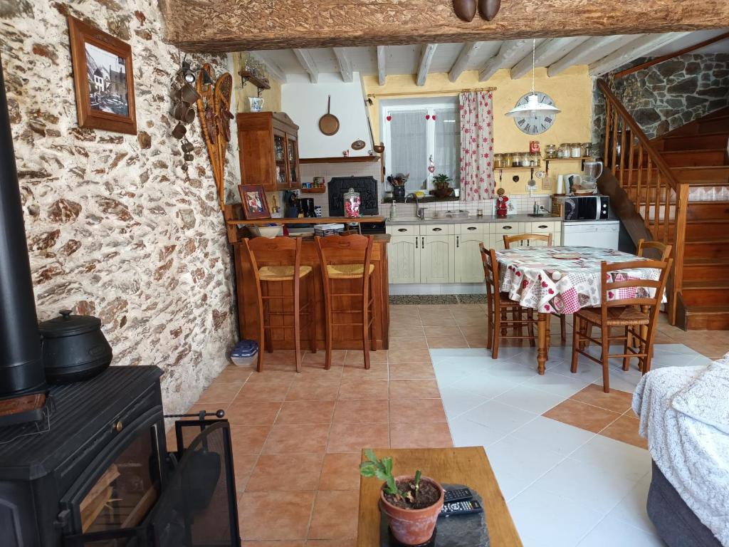 une cuisine et un salon avec une table et des chaises dans l'établissement Maison de village à la montagne, à Fos