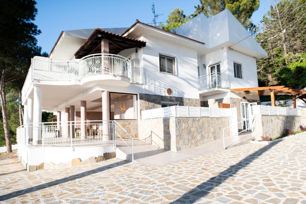 a white house with a stone driveway at Sole & Pepe in Santa Maria di Castellabate