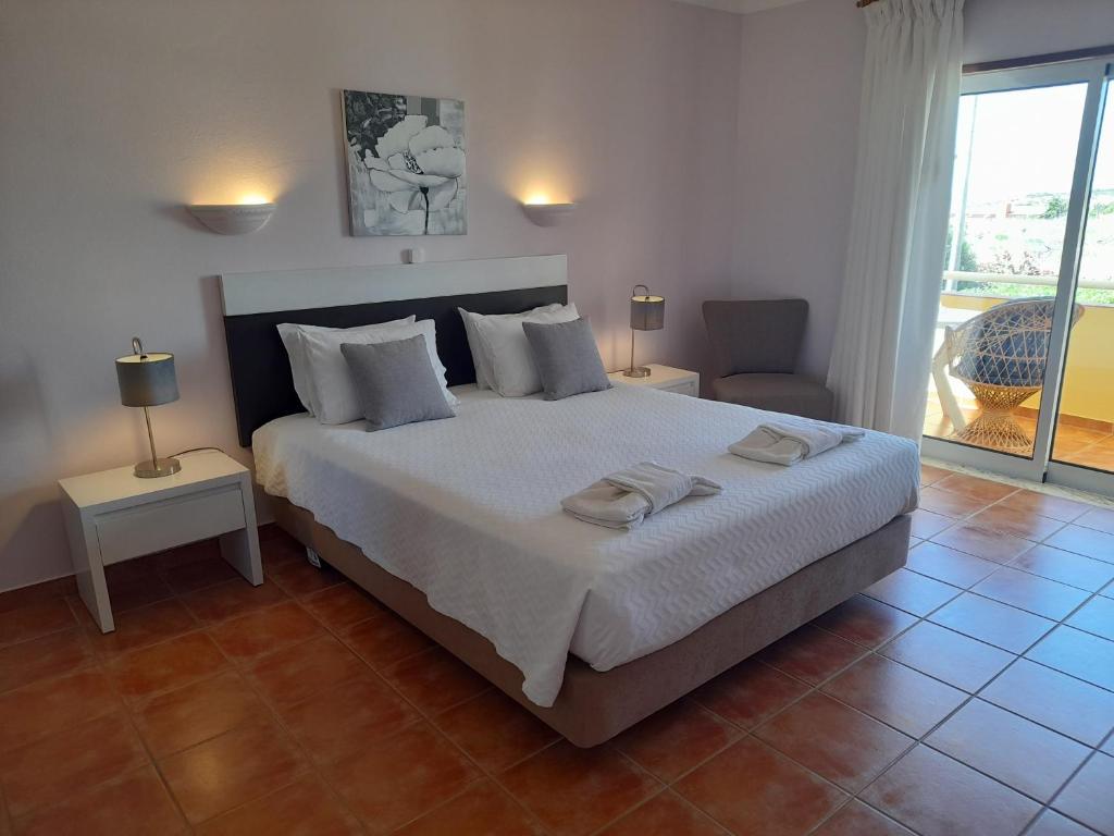 a bedroom with a large bed with two towels on it at Aurora Sol in Luz