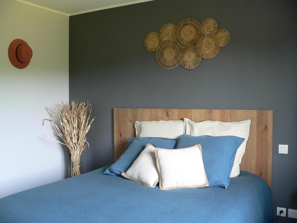 a bedroom with a blue bed with white pillows at La petite chambre du lac in Carcassonne