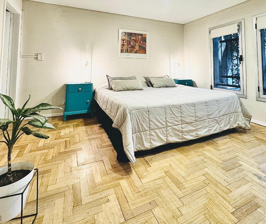 1 dormitorio con 1 cama y suelo de madera en Jaque Mate Hostel en Mendoza