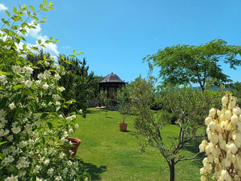 um jardim com um gazebo ao fundo em Villa Casa Belvedere near Dubrovnik em Gruda