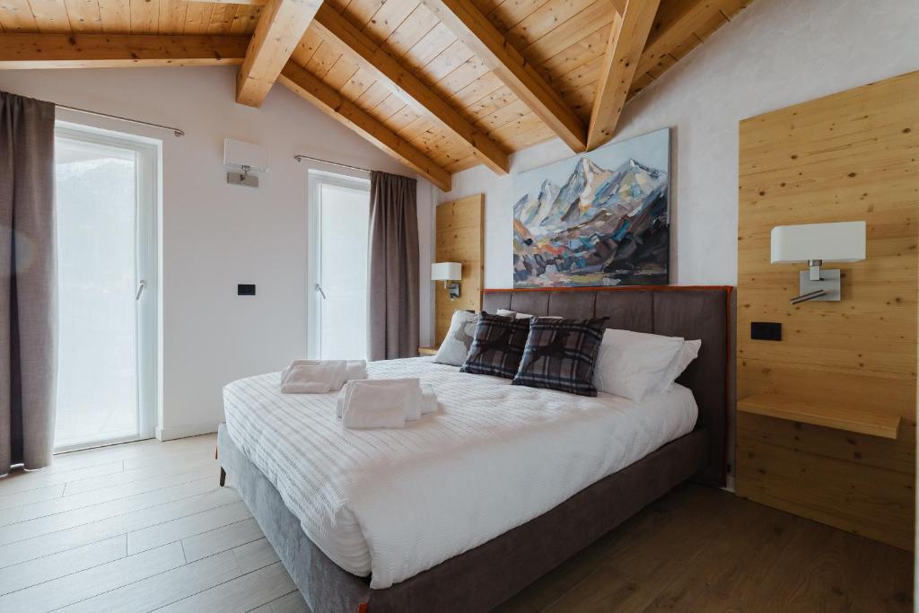 a bedroom with a large bed in a room with wooden ceilings at PINZOLO MOUNTAIN LODGE in Pinzolo