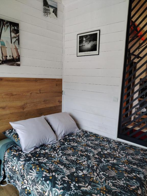 une chambre avec un lit dans une pièce aux murs blancs dans l'établissement Chez Cristele et David, à Capbreton