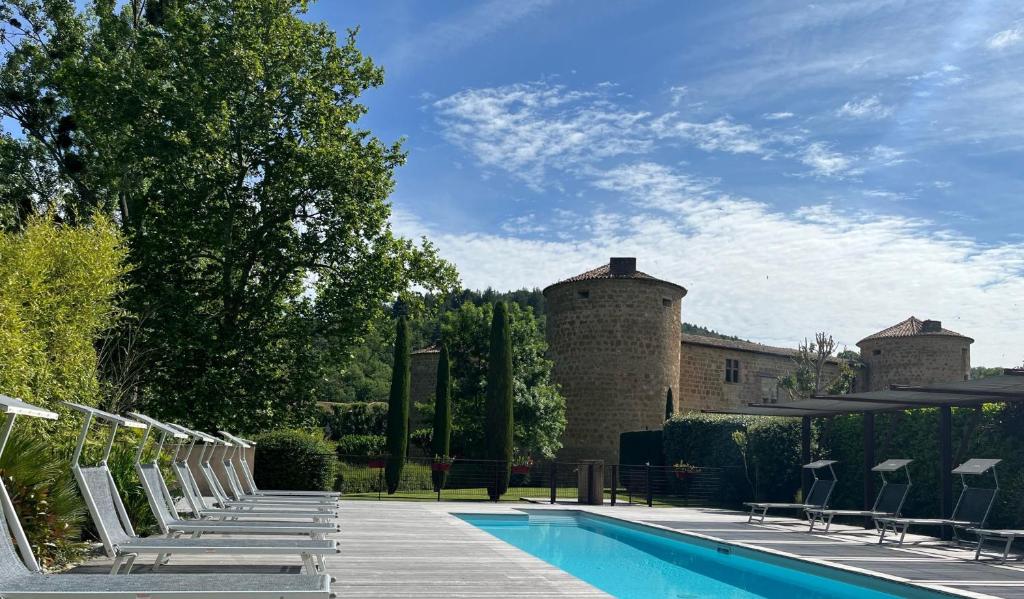 a swimming pool with chairs next to a building at Château Des Ducs De Joyeuse in Couiza
