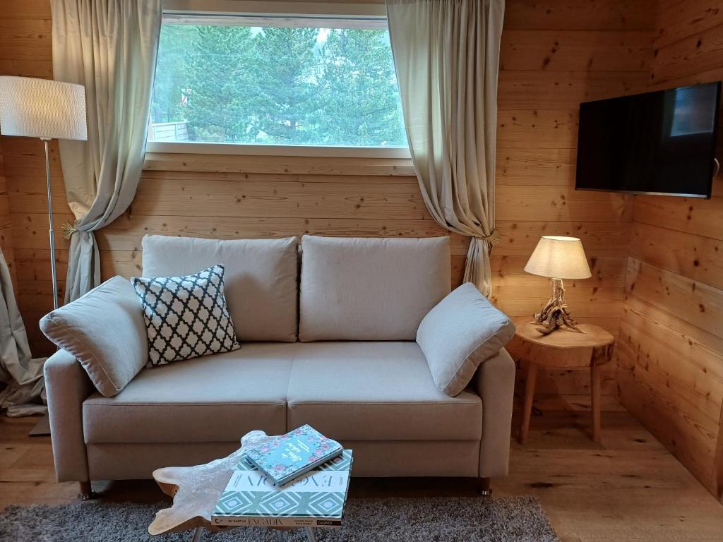 un soggiorno con divano e finestra di Hotel Chesa Staila a La Punt-Chamues-ch