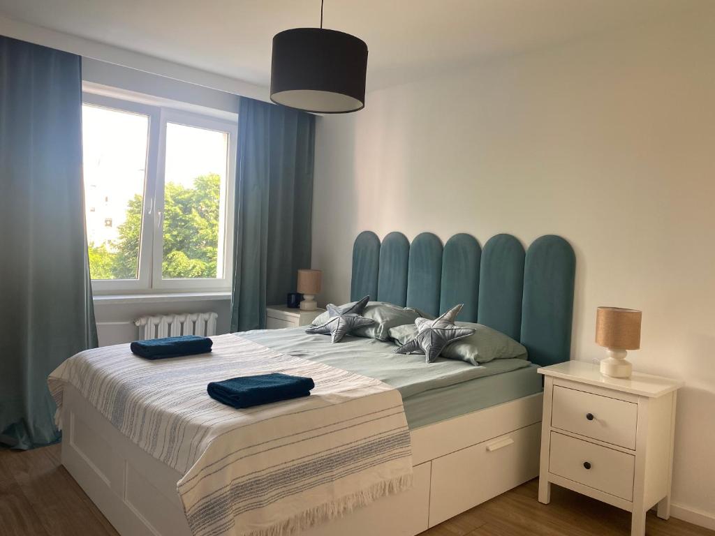 une chambre avec un grand lit et une tête de lit bleue dans l'établissement Złotów 9, à Złotów