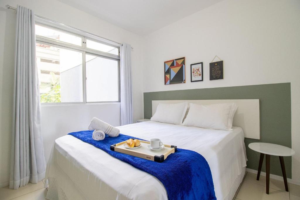 a bedroom with a bed with a tray of food on it at JAO32 - 1 Suíte, TV Smart, Wi-Fi in Balneário Camboriú