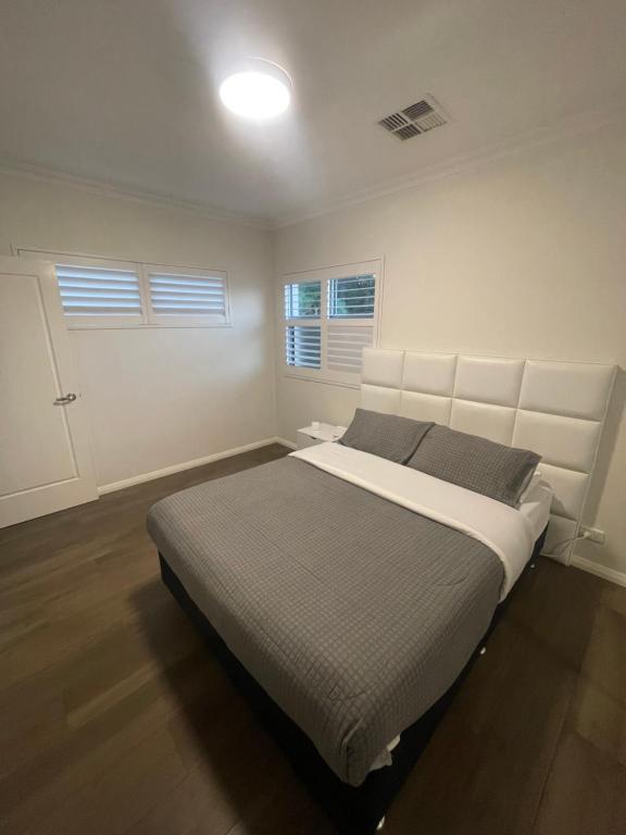 Un dormitorio blanco con una cama grande. en Modern room in Perth city !!, en Perth