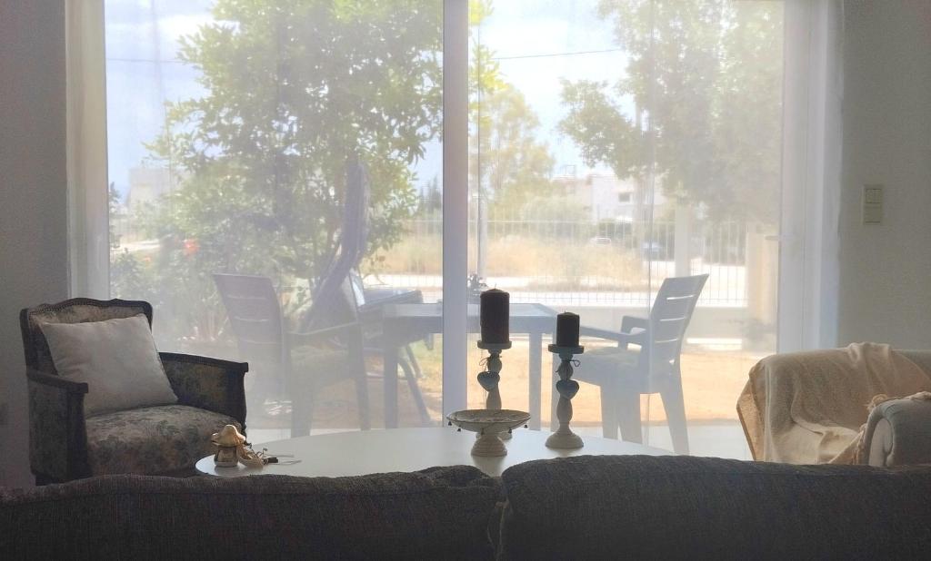 a living room with a couch and a table with two candles at Lovely Place in Akharnaí