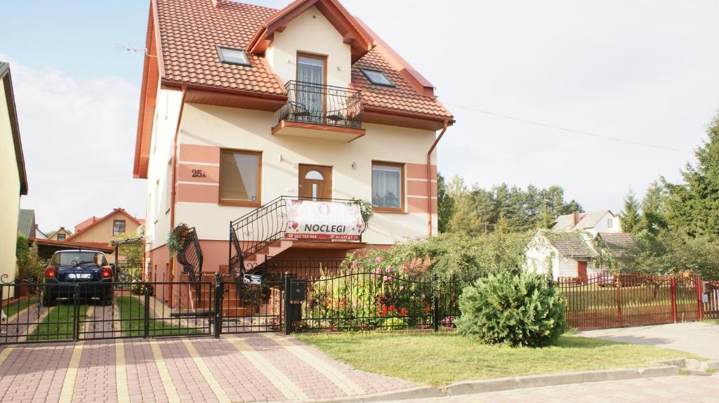 una casa con una valla negra delante de ella en Noclegi Pod Różą en Krasnobród