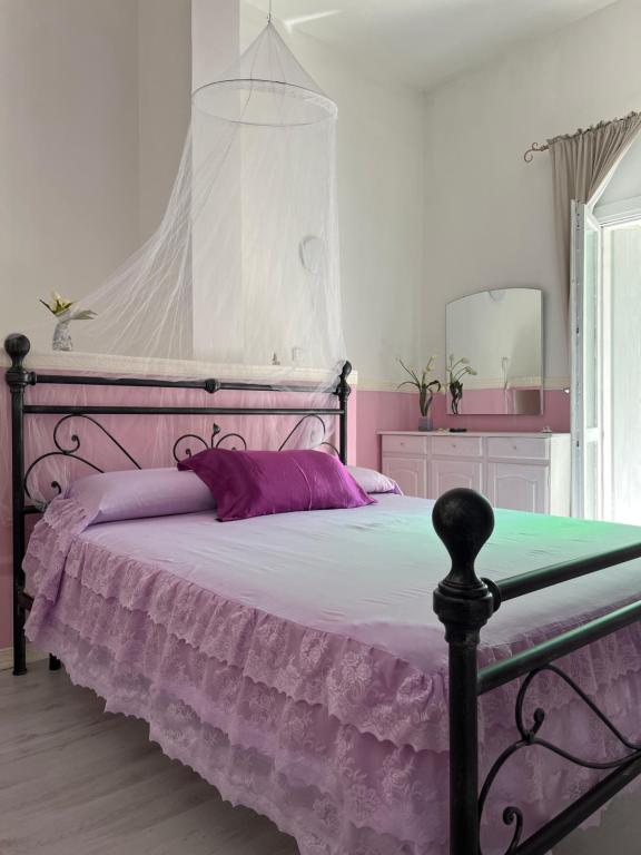 um quarto com uma cama com uma colcha roxa em Casa di vacanza "San Nicola" em Olbia