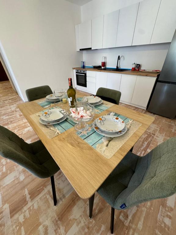 una mesa de comedor con platos y una botella de vino en Apartment Gjoli, en Durrës