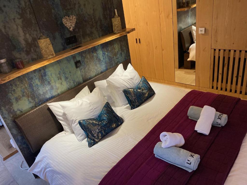 uma cama grande com almofadas e toalhas em L’Oxymore em Waimes