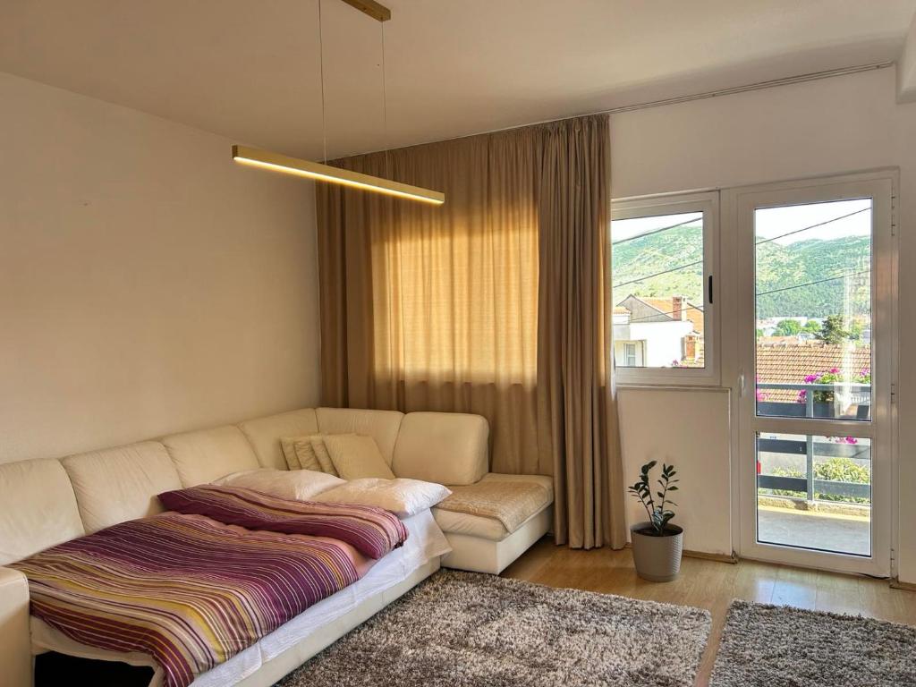 sala de estar con sofá y ventana en Apartmani Andric, en Trebinje